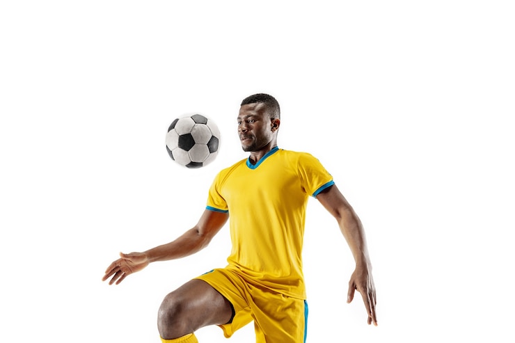 Photo joueur de football professionnel de football afro-américain en mouvement isolé sur fond de studio blanc. fit l'homme en action, saut, mouvement au jeu. le concept de prise, de passe