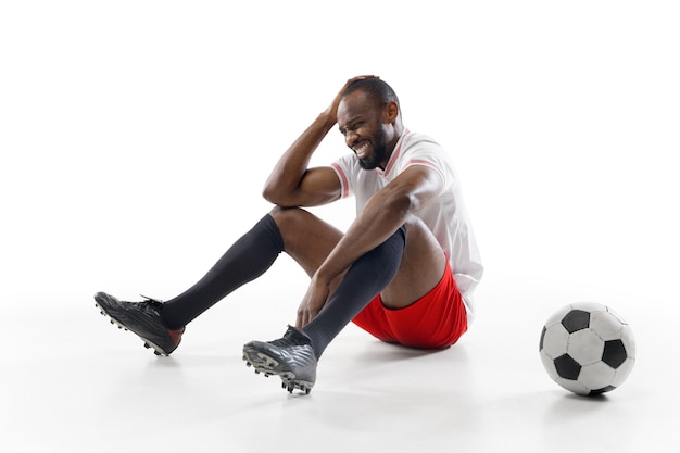 Joueur de football professionnel isolé sur le mur du studio blanc