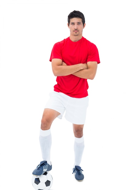 Joueur de football en rouge debout avec une balle