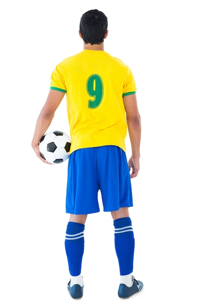 Joueur de football en tenant la boule jaune