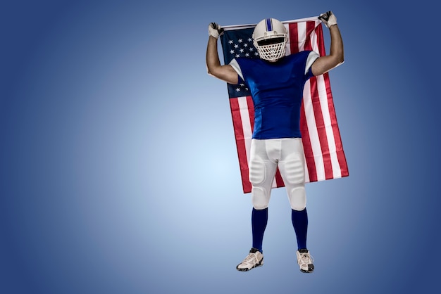 Joueur De Football Avec Un Uniforme Bleu Et Un Drapeau Américain, Sur Un Mur Bleu