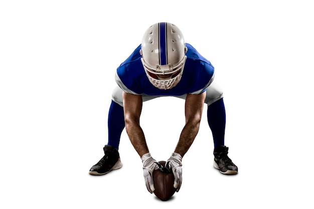 Joueur de football avec un uniforme bleu sur la ligne de mêlée sur un mur blanc