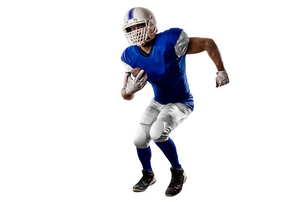 Photo joueur de football avec un uniforme bleu s'exécutant sur un mur blanc