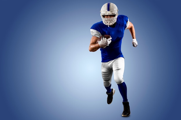 Joueur de football avec un uniforme bleu s'exécutant sur un mur bleu