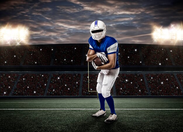 Joueur de football avec un uniforme bleu sur un stade