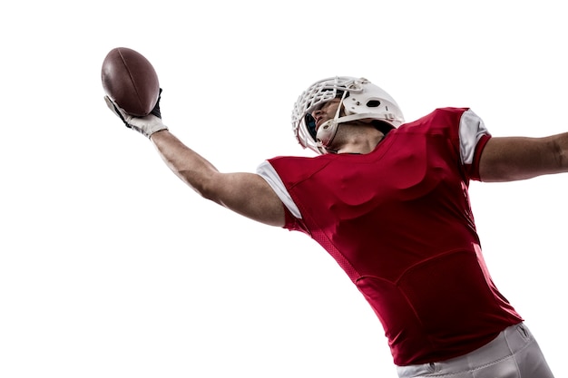 Joueur de football avec un uniforme rouge faisant une capture sur blanc