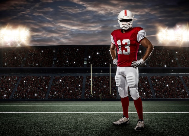 Joueur de football avec un uniforme rouge sur un stade.