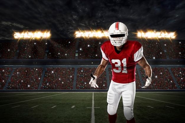 Joueur de football avec un uniforme rouge sur un stade.