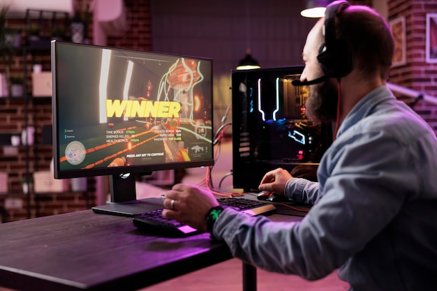 Joueur gagnant un jeu vidéo sur un PC puissant