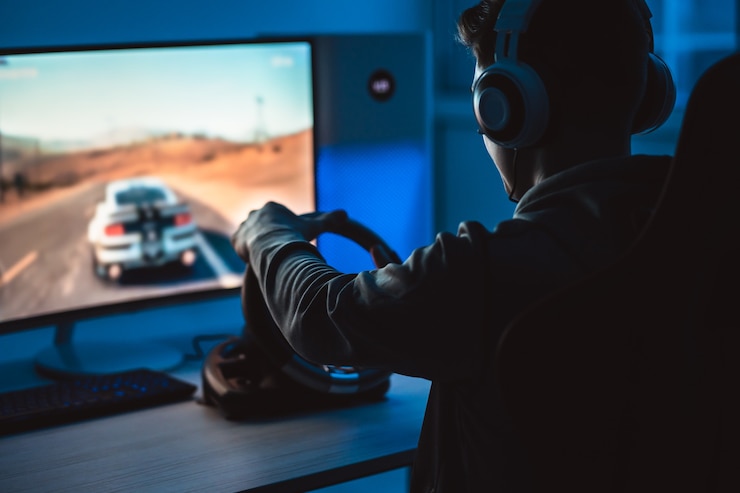 Photo le joueur de gars avec des écouteurs jouant à des jeux vidéo dans la pièce sombre