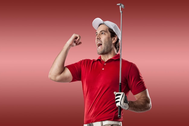 Joueur de golf dans une chemise rouge célébrant, sur fond rouge.