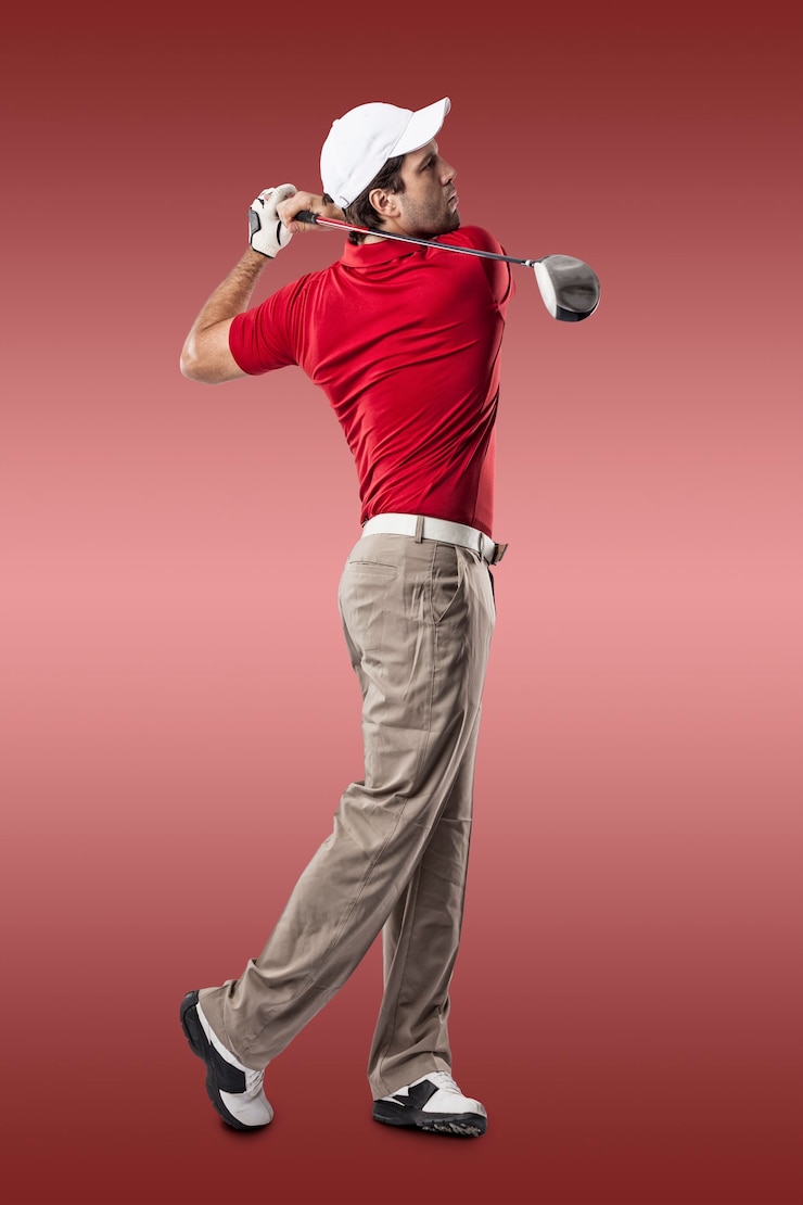 Photo joueur de golf dans une chemise rouge prenant un swing, sur un fond rouge.