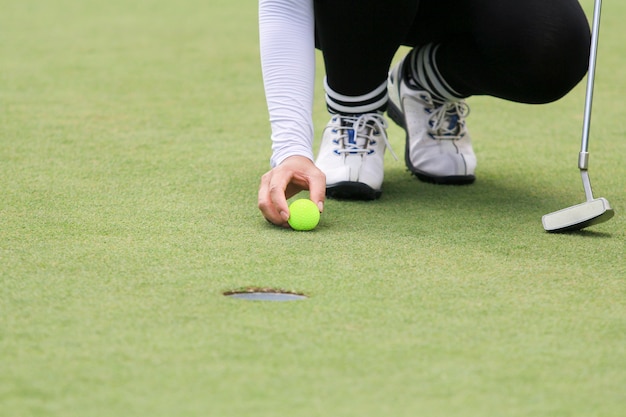 Joueur de golf femme mettant sur le green