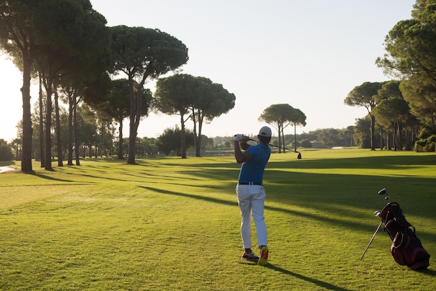 joueur de golf frappant avec chauffeur sur le parcours lors d'une belle journée ensoleillée