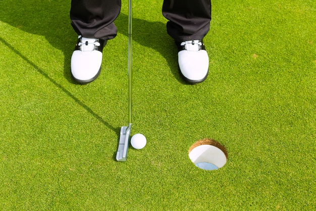 Joueur de golf mettre la balle dans le trou