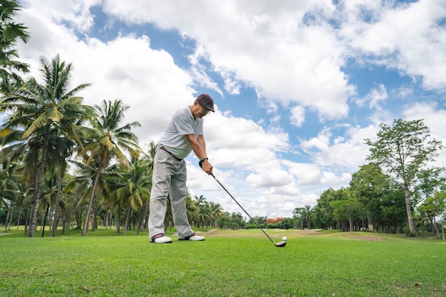 Joueur de golf senior jouant au golf dans un parcours de golf professionnel.