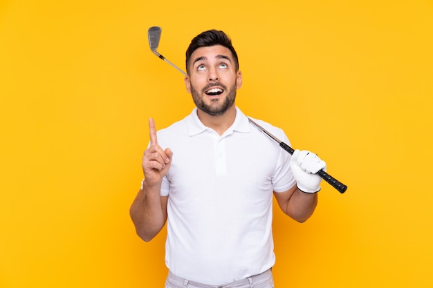 Joueur de golfeur homme sur mur jaune isolé pointant vers le haut une excellente idée