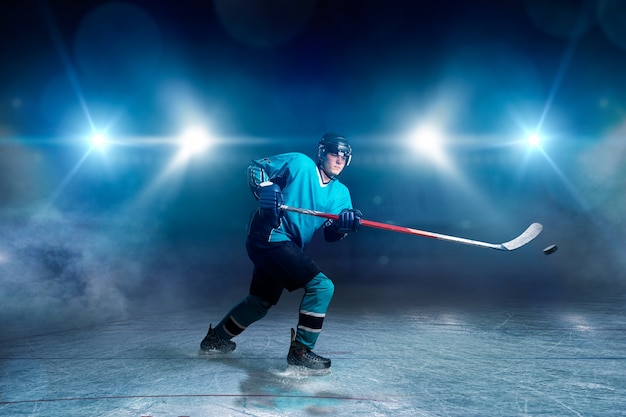 Joueur de hockey avec bâton et rondelle fait un lancer