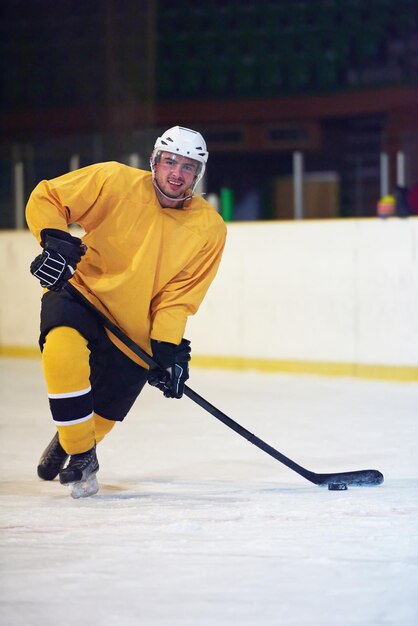 Joueur de hockey sur glace en action donnant des coups de pied avec un bâton