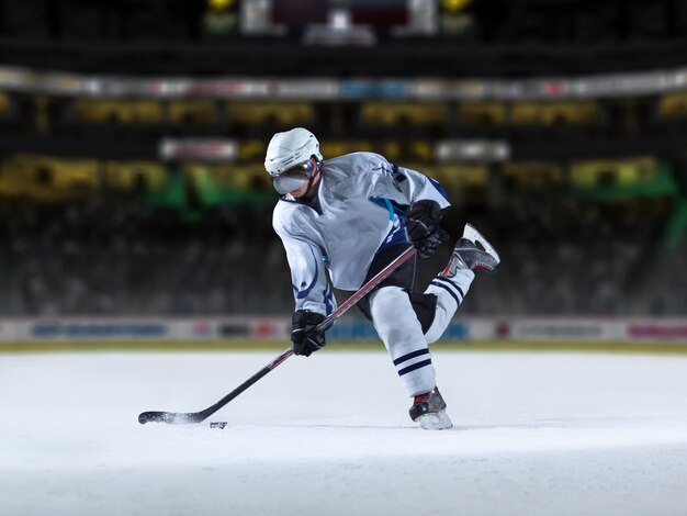 Joueur de hockey sur glace en action donnant des coups de pied avec un bâton