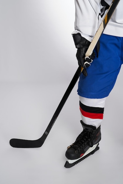 Joueur de hockey sur glace masculin méconnaissable avec bâton en studio