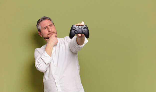 Joueur de l'homme d'âge moyen avec une télécommande