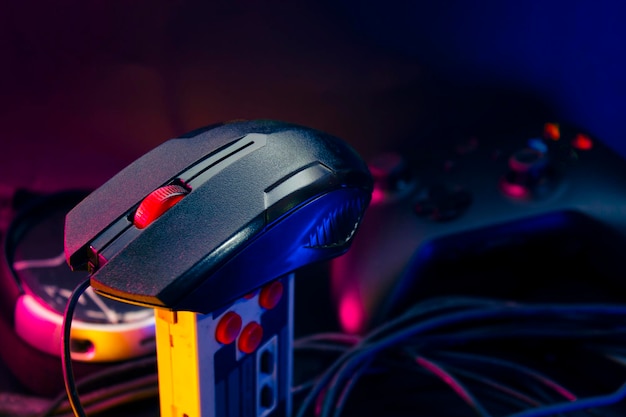 Joueur jouant au jeu en ligne avec un contrôleur de joystick dans une salle de jeu cyberpunk sombre néon et un tournoi de défi esports streamer en streaming avec un appareil analogique dans la maison d'habitation