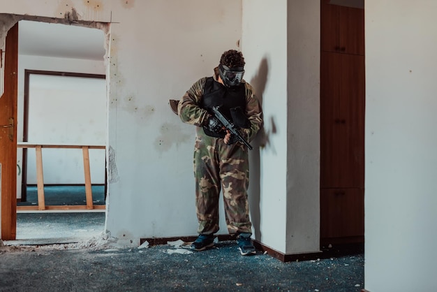 Joueur de paintball en masque qui vise les adversaires à l'arène de paintball Mise au point sélective