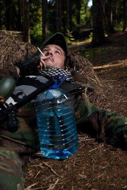 Joueur de paintball se reposant et fumant un cigare