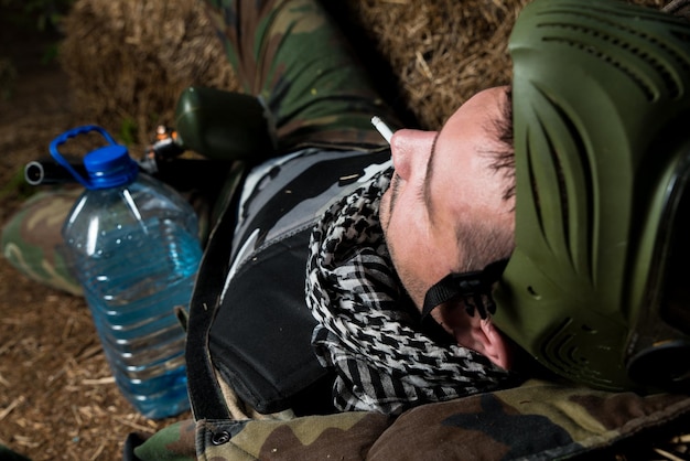 Joueur de paintball se reposant et fumant un cigare