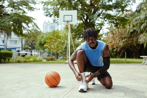 Un joueur de streetball attache des lacets de chaussures.