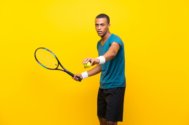 Joueur de tennis afro-américain sur jaune isolé