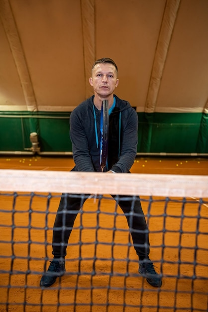 Joueur de tennis athlète agile qui joue au tennis sur un court intérieur