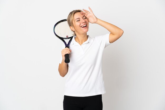 Joueur de tennis jeune femme russe isolé sur blanc souriant beaucoup