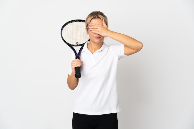 Joueur de tennis jeune femme russe isolé sur fond blanc couvrant les yeux par les mains. Je ne veux pas voir quelque chose