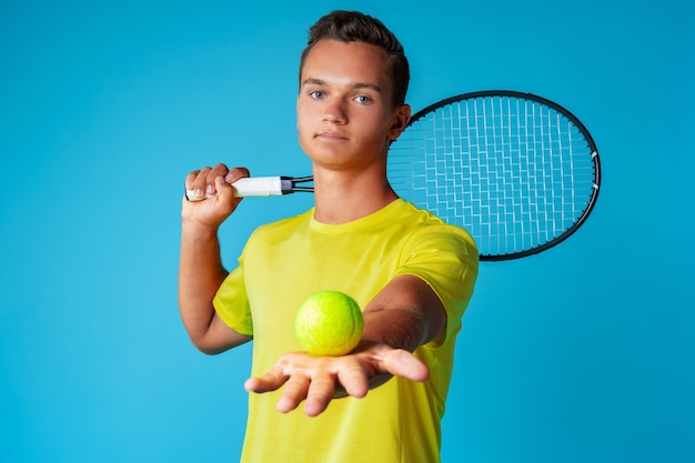 Photo joueur de tennis jeune homme en tenue de sport posant contre le bleu