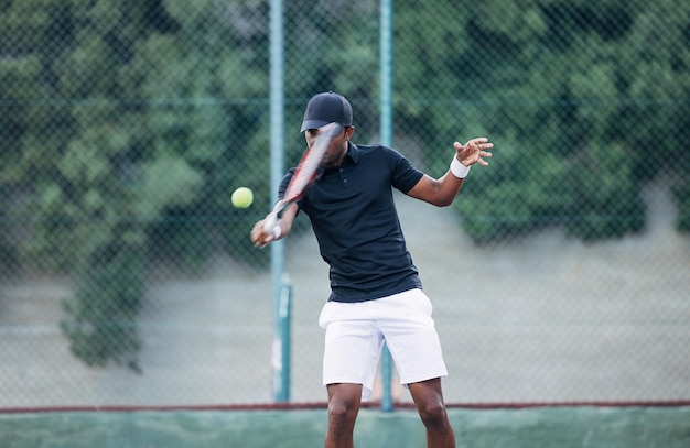 Joueur de tennis professionnel frappant la balle à l'extérieur