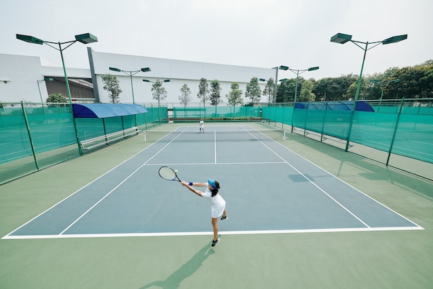 Joueur de tennis sautant et frappant la balle