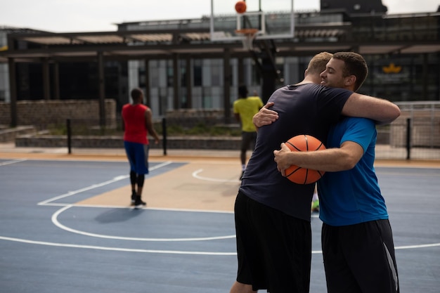 Des joueurs de basket s'embrassent sur le terrain de basket