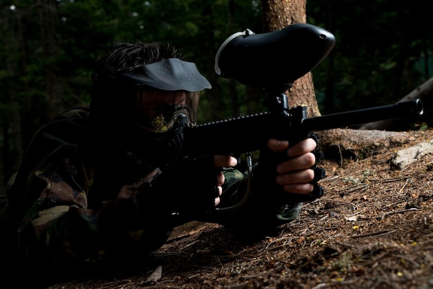 Les joueurs de paintball se cachent derrière l'arbre