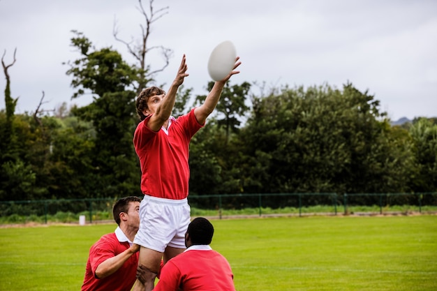 Joueurs de rugby sautant pour la ligne