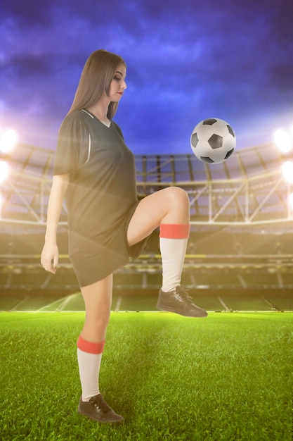 Joueuse de football femme avec ballon de football au stade