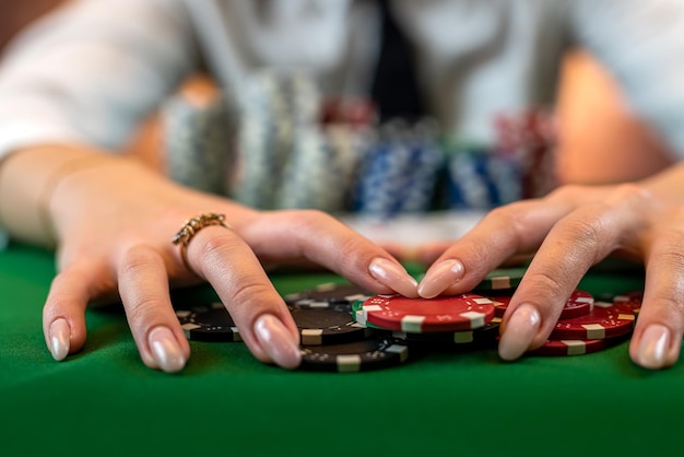 Une joueuse de poker professionnelle fait un geste avec des cartes et des jetons à la table