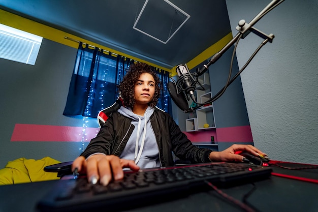 Une joueuse professionnelle joue dans un jeu vidéo sur son ordinateur Elle participe à un tournoi de cyber-jeux en ligne Joue à la maison ou dans un cybercafé Elle porte un casque de jeu