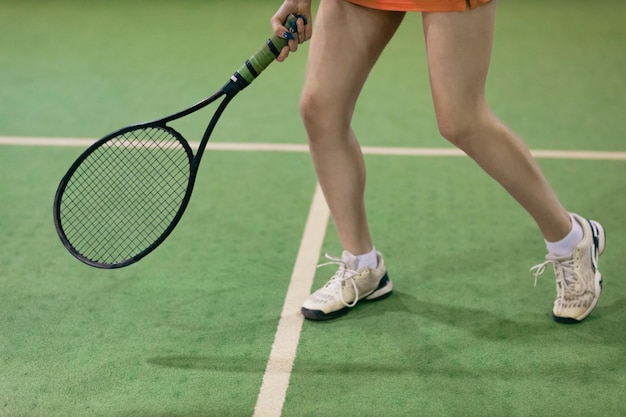 Joueuse de tennis jouant à l'entraînement avec raquette et balle au tribunal