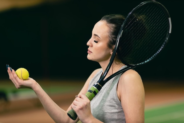 Joueuse de tennis jouant à l'entraînement avec raquette et balle au tribunal