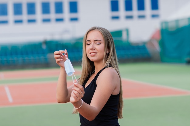 Joueuse de tennis jouant avec un masque de protection sur la cour