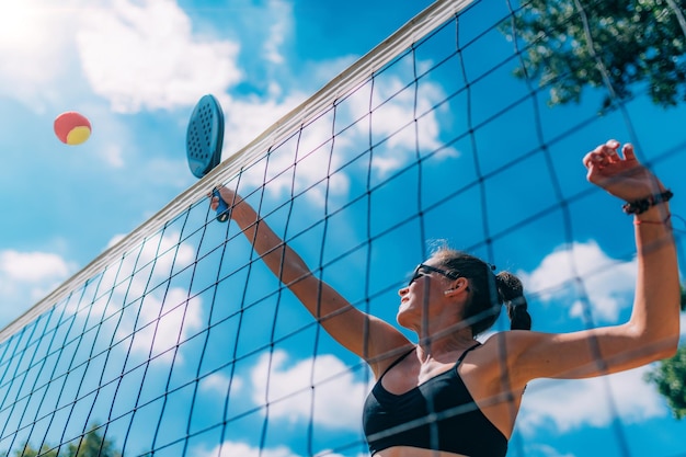 Joueuse de tennis de plage au filet