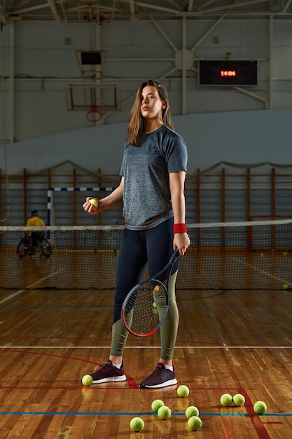 Joueuse de tennis avec raquette et balle sur fond de gym