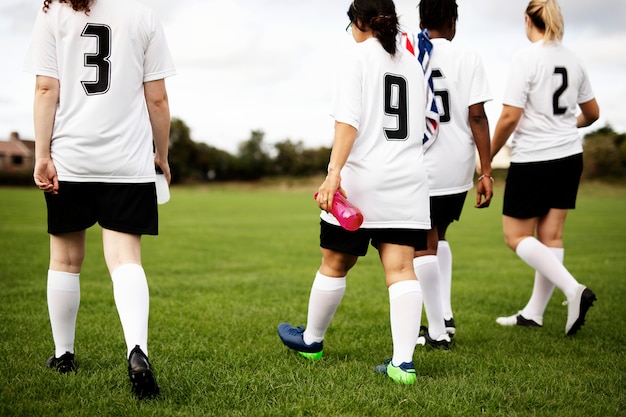 Joueuses de football junior marchant sur un terrain